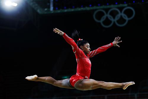 Simone Biles leaping during a floor routine.