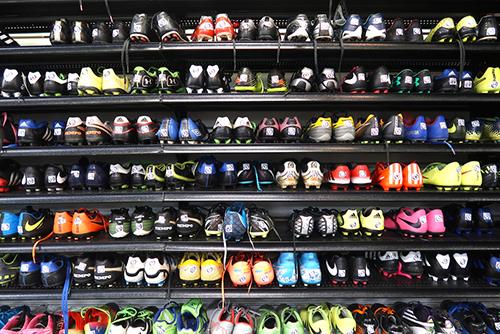 Wall of used sports shoes for sale.