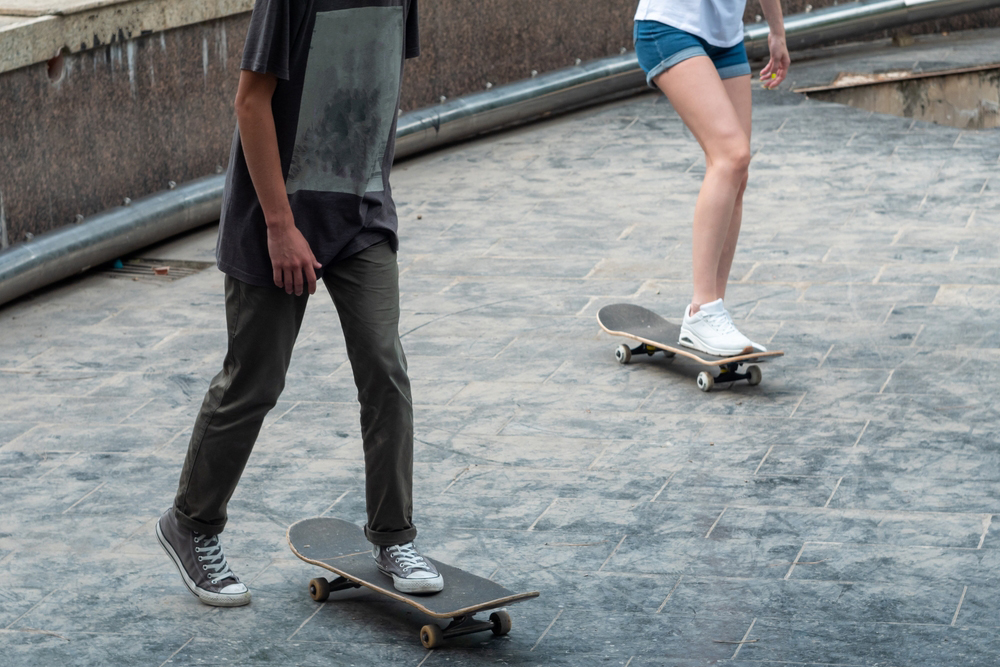 Young boy and girl skateboarding.