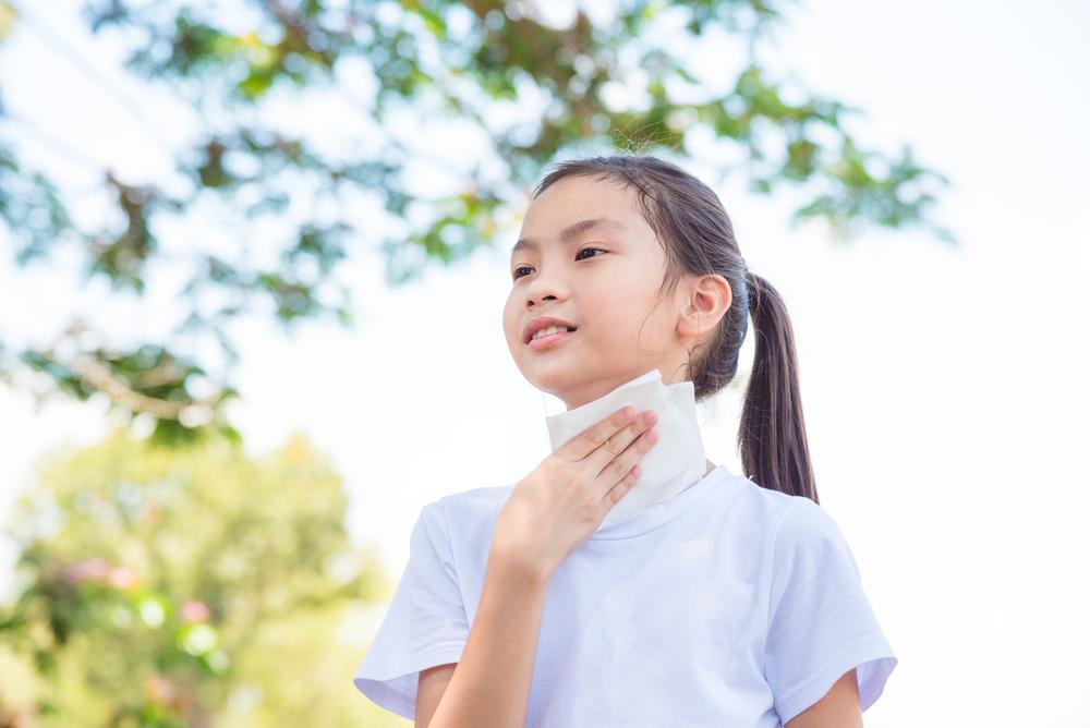 Young asian girl sweating outside.