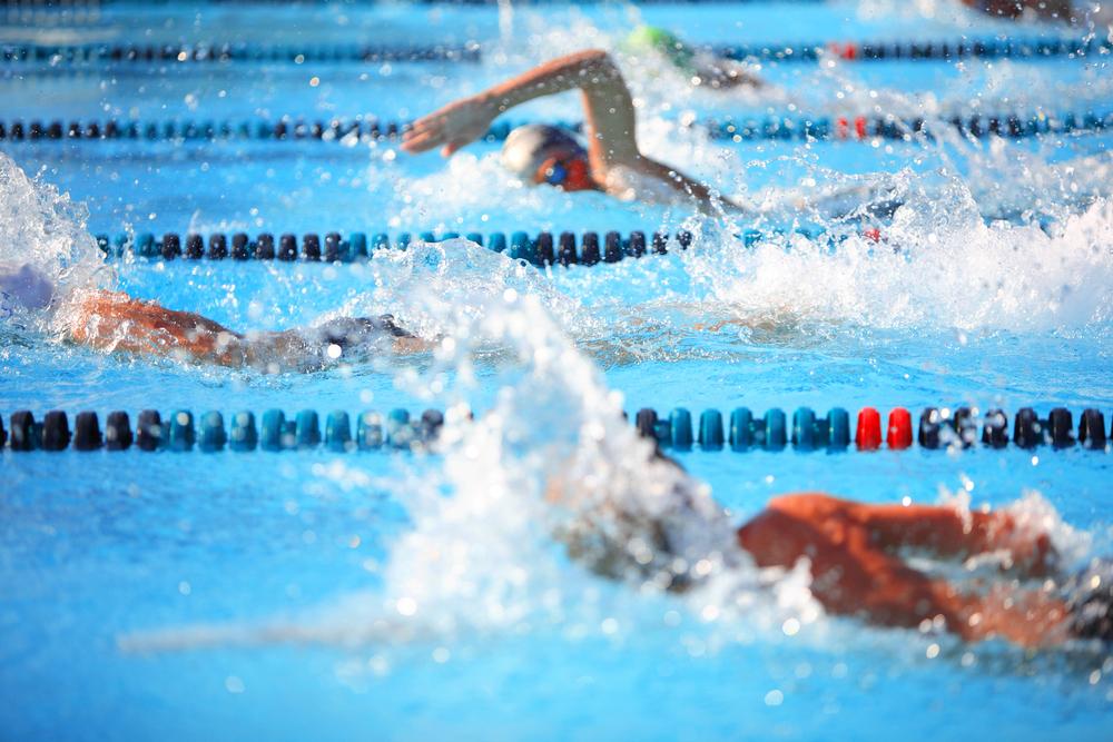 Young boys competing in outdoor swim competition.