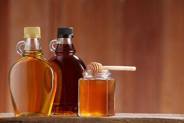 Bottles of maple syrup and honey.