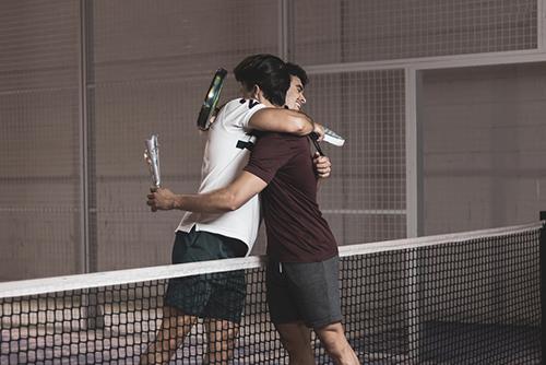 Two young male tennis players hugging.