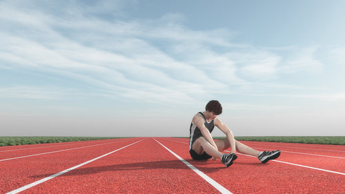 Track athlete sitting alone on the track.