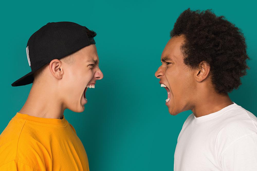 Two teen boys yelling angrily at each other.