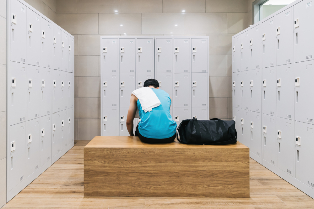 Tired athlete alone in locker room.