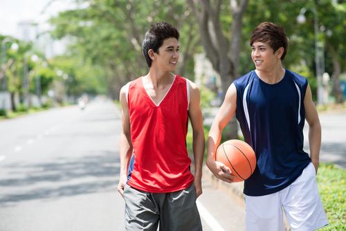 Two young male basketball players talking.