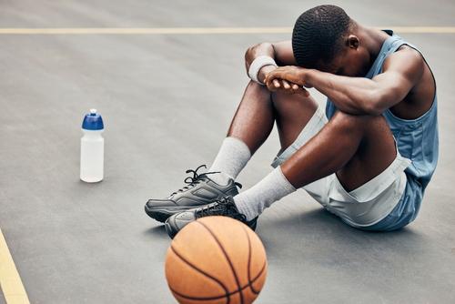Young black male upset on basketball court.