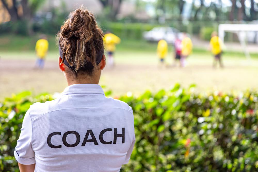 Female coach wearing a shirt that says "coach."
