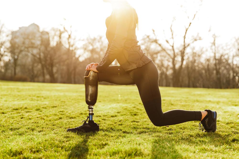 Woman stretching with prosthetic leg.