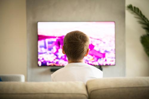 Young boy sitting in front of a television.