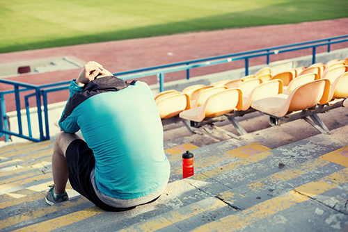 Young male on stadium steps alone.