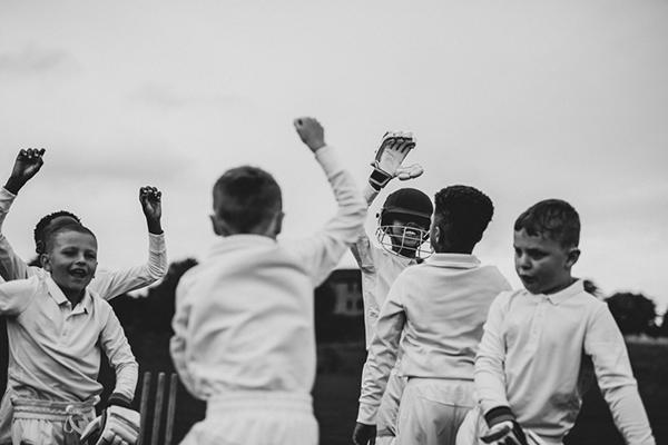 Young team of male cricket players celebrating.