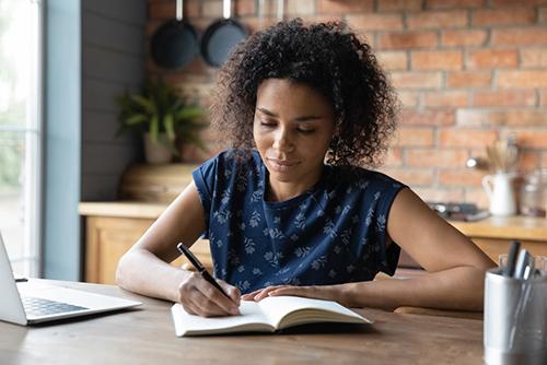 Young woman writing in a notebook.